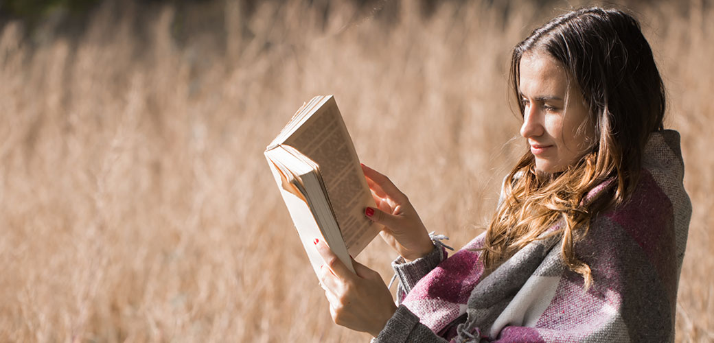 Persoon leest boek in plaats van telefoon